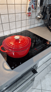 a red pot is sitting on a stove with the number 7 on the display