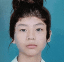 a close up of a young girl 's face with a bun on her head .