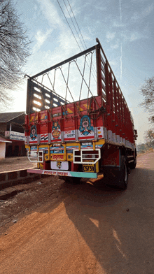 a red truck with the license plate c57 39 is parked on a dirt road