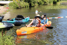 a man in an orange kayak with the word malibu on the front