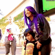 a woman with purple hair is standing next to a little boy wearing a shirt that says ' burger ' on it