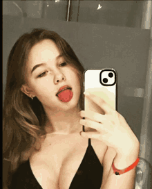 a woman is taking a selfie with her tongue hanging out