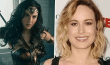 a woman in a wonder woman costume and a woman in a black dress are standing next to each other .