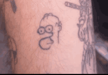 a person has a tattoo of homer simpson on their arm