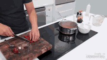 a man is cutting red peppers on a wooden cutting board with the words made in animatica on the bottom