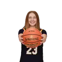 a woman holding a spalding legacy basketball