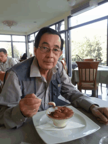 a man is sitting at a table eating a dessert