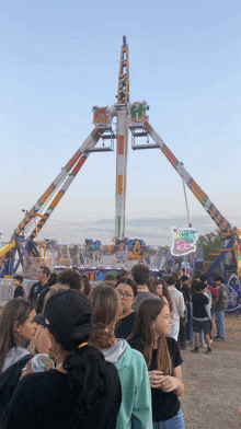 a group of people are standing in front of a carnival ride called rock n ' roll