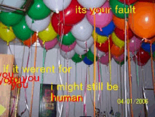 a bunch of balloons hanging from the ceiling with the words " it 's your fault " on top