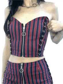 a woman is wearing a red and blue striped top with a zipper on the front