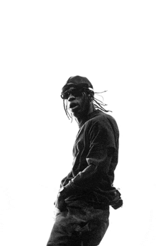 a black and white photo of a man with dreadlocks and sunglasses