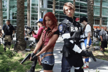 a man in a r.p.d. uniform stands next to a woman holding guns