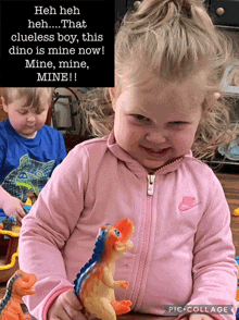 a little girl in a pink nike jacket is holding a dinosaur toy