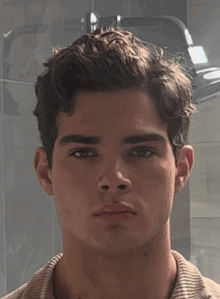 a close up of a young man 's face looking at the camera