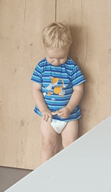 a little boy wearing a blue striped shirt with a picture of ducks on it