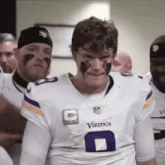 a man wearing a white vikings jersey with the number 8 on it