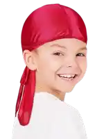 a young boy wearing a red bandana on his head is smiling .