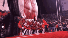 a group of football players are lined up in front of a giant inflatable elephant with the number 7 on it