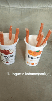 two cups of fruita yogurt with sausage sticks in them