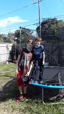 two boys standing on a trampoline with one wearing a shirt that says ' snoopy ' on it