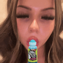 a woman blowing a bubble with a bottle that says puff licker in front of her