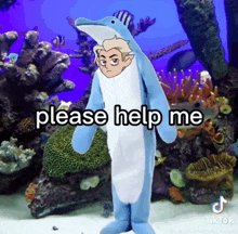 a man in a dolphin costume is standing in front of an aquarium .