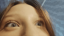 a close up of a woman 's face with her eyes looking up