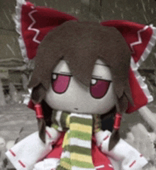 a stuffed doll with red ears and a scarf around her neck .