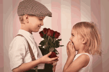 a little boy is giving a little girl a bouquet of roses