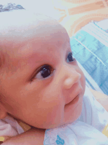 a close up of a baby 's face with a blue and white bib