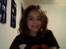 a young girl wearing a black shirt with a mickey mouse on it