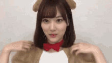 a young woman is wearing a dog costume with ears and a bow tie .