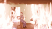 a nurse is sitting in a chair in front of a wall of flames