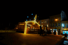 a nativity scene is lit up at night in front of a building that says pharmacy