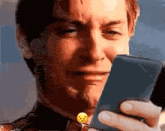 a man is crying while looking at his phone .