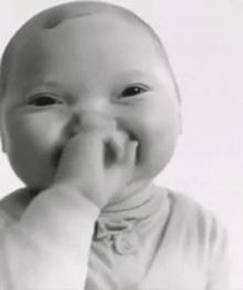 a black and white photo of a baby putting his finger in his mouth