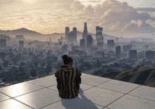 a person sitting on a tiled surface looking at a city skyline