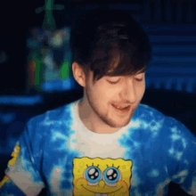 a man wearing a blue tie dye shirt with spongebob squarepants on it