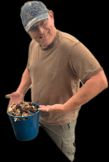 a man is holding a blue bucket filled with mushrooms