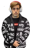 a man wearing headphones and a black jacket that says supreme on it