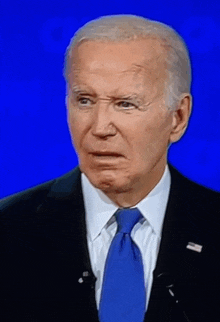 a man in a suit and tie is standing in front of a blue screen