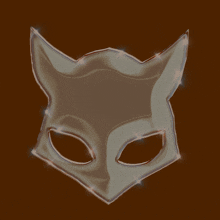 a cat mask on a brown background with sparkles on it