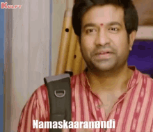 a man in a striped shirt is holding a bag and says namaskaaranandi