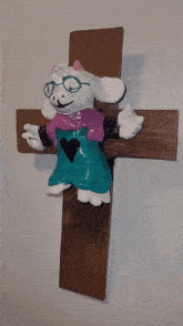 a stuffed animal is sitting on a cross
