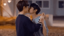 a couple of young men are kissing each other while dancing .