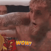 a man with a tattoo on his arm has the word wow written on his chest