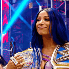 a woman with blue hair is holding a championship belt