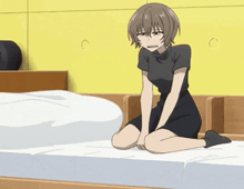 a girl is kneeling on a bed with her legs crossed