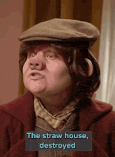 a man wearing a hat and a scarf says " the straw house destroyed "