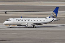 a united express passenger jet is sitting on the runway .